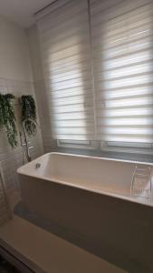 a white bath tub in a bathroom with a window at Appartement 120 m² Standing Hyper Centre Climatisé in Perpignan