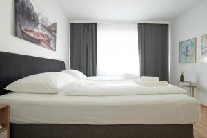 a bedroom with a large white bed with a window at Charming Apartment with Balcony, Close to Stephansdom Cathedral in Vienna