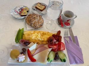 una mesa blanca con un plato de comida y una bebida en Hotel Select, en Sibiu