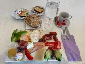 a table with a plate of food and a glass of wine at Hotel Select in Sibiu