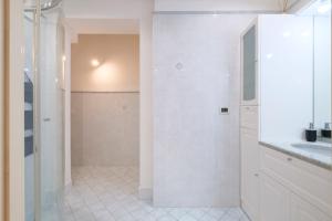 Un baño blanco con ducha y lavabo. en Fusari 4 by Studio Vita, en Bolonia