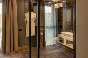 a dressing room with a sink and a glass display case at Hotel Vibre in Cluj-Napoca