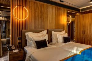 two beds in a hotel room with lights on the wall at Hotel Vibre in Cluj-Napoca