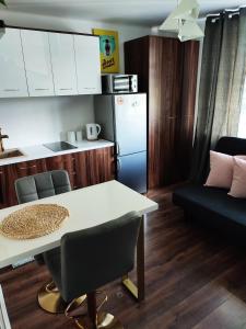 a kitchen with a white table and a refrigerator at Apartamenty Urban Concept in Zamość