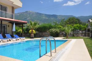 a swimming pool in a house with mountains in the background at Villa Mountain View in Fethiye