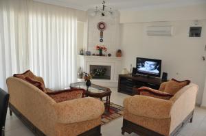 uma sala de estar com duas cadeiras e uma televisão em Villa Mountain View em Fethiye