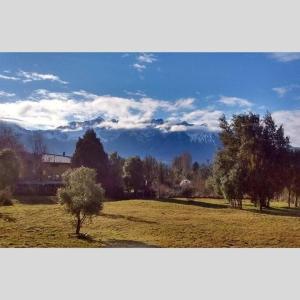 een veld met bomen en een berg op de achtergrond bij Casa Nehuen in Lago Puelo +5 foto's
