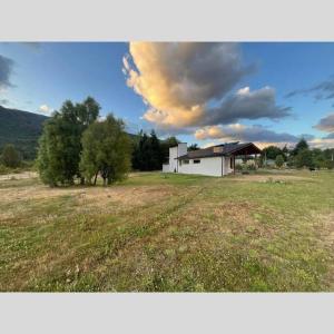 een groot veld met een huis op de achtergrond bij Casa Nehuen in Lago Puelo
