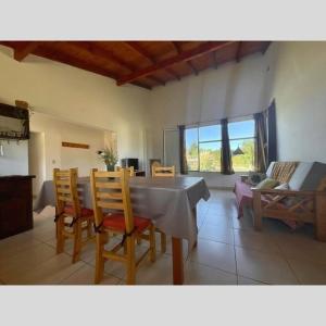 een woonkamer met een tafel, stoelen en een bank bij Casa Nehuen in Lago Puelo