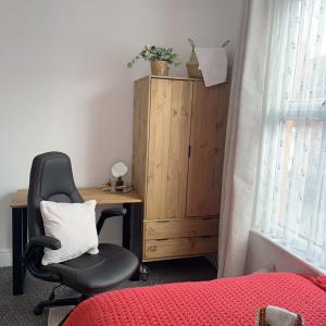 1 dormitorio con escritorio y silla junto a la cama en Monk’s Lodge en Parkside
