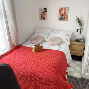 a bedroom with a bed with a red blanket at Monk’s Lodge in Parkside