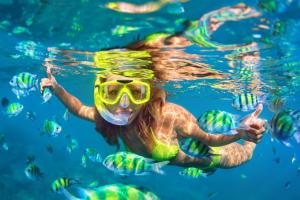 a woman swimming in the water with a snorkel at A Son de Mar - Playa Las Gatas acceso por mar in Zihuatanejo