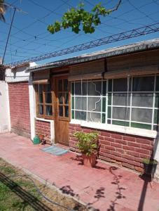 een stenen huis met een houten deur en ramen bij Casa en la Ruta del Vino in Mendoza