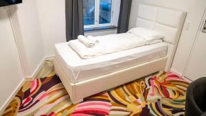 un letto bianco in una stanza con un tappeto di A Hotels City a Copenaghen