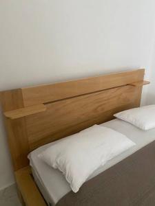 ein hölzernes Kopfteil aus einem Bett mit zwei weißen Kissen in der Unterkunft Bel appartement en loma au calme in Las Terrenas