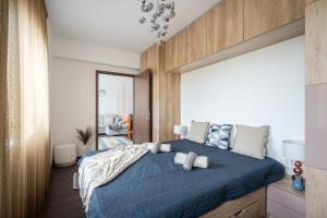 a bedroom with a blue bed with a large window at Premier Pest Side Apartment in Budapest