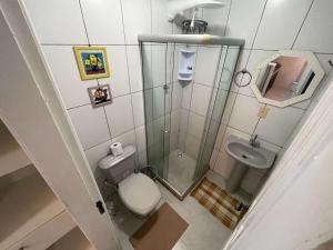 Un baño pequeño con inodoro y lavabo. en Central Praias Suíte 2, en Cabo Frío
