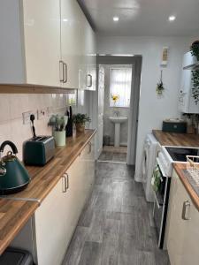 a kitchen with white cabinets and wooden counter tops at Monk’s Lodge in Parkside +2 photos