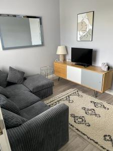 a living room with a couch and a table with a tv at Herbies Stay in Southend-on-Sea