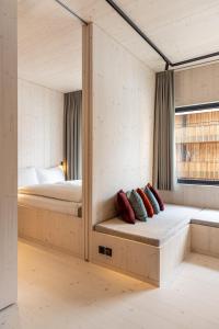 1 dormitorio con cama y ventana con almohadas en Stenna Loft - Self check-in apartments, en Flims