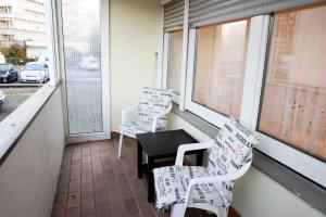 balcón con 2 sillas, mesa y ventanas en Cozy Apartment in Eppelheim, en Eppelheim