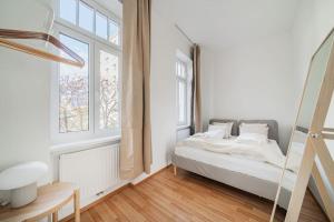 a white bedroom with a bed and a window at City Chic #18 in Vienna