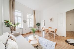a white living room with a white couch and a table at City Chic #18 in Vienna
