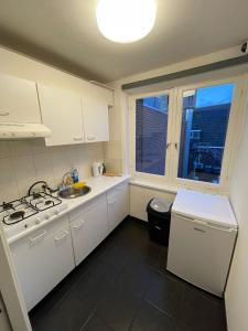 a white kitchen with a sink and a stove at Room With Two Beds in Centrum in Heerlen
