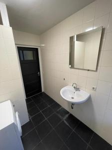 a bathroom with a sink and a mirror and a door at Room With Two Beds in Centrum in Heerlen