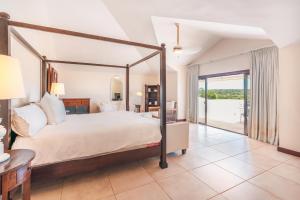 a bedroom with a large bed and a balcony at Seaside Bliss with pool and spectacular view in Las Minas