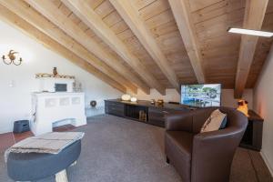 - un salon mansardé avec un plafond en bois dans l'établissement Partnachauen, à Garmisch-Partenkirchen