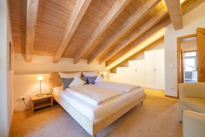 - une chambre avec un grand lit et un plafond en bois dans l'établissement Partnachauen, à Garmisch-Partenkirchen