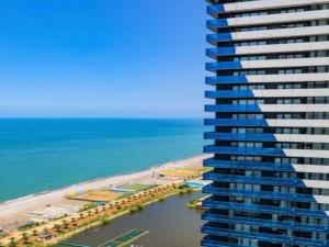 un grand bâtiment à côté de la plage et de l'océan dans l'établissement Orbi City Central Aparthotel, à Batoumi