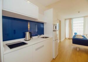 a kitchen with a sink and a refrigerator at Orbi City Central Aparthotel in Batumi