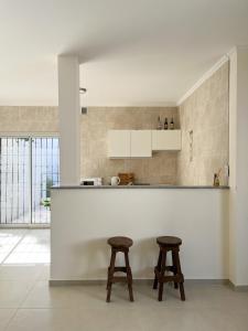 a kitchen with two stools sitting at a counter at Departamentos Plaza Santo Tomé, Santa Fe in Santo Tomé