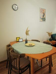 a dining room table with chairs and a clock on the wall at Atlas Apartment in the historical center of Košice with free private parking in Košice