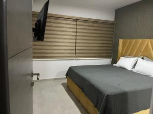 Schlafzimmer mit einem Bett und einem Fenster mit einem TV in der Unterkunft Bluu Habitat Lagoons in Mazatlán