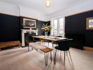 a dining room with a table and chairs and a fireplace at Sunrise House in Lowestoft