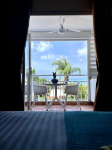 - une chambre avec vue sur un balcon doté d'une table et de chaises dans l'établissement Chez Valérie et Pascal, à La Trinité