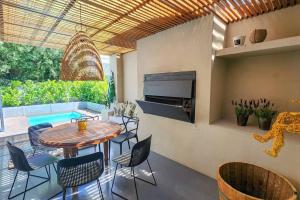 un patio con tavolo, sedie e piscina di House of Anjel a Suider-Paarl