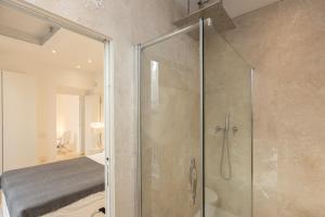 uma casa de banho com um chuveiro e uma porta de vidro em Amazing Cozy Piazza Venezia em Roma