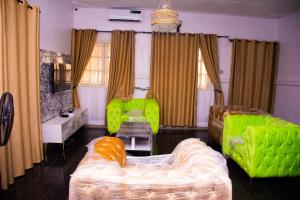salon z zielonymi meblami i kanapą w obiekcie Xproject Homes w mieście Ibadan