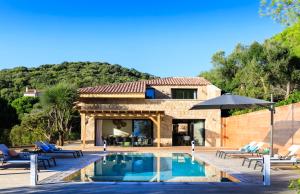 a villa with a swimming pool and a house at The Beach House in Olmeto