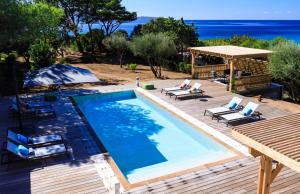 a swimming pool with chairs and a gazebo at The Beach House in Olmeto