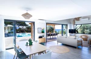 a living room with a table and a dining room at The Beach House in Olmeto