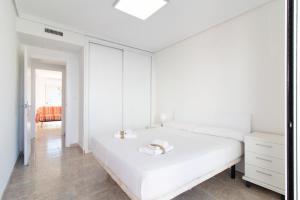 カネット・デ・ベレンゲルにあるGlobal Properties, Las dachas 1 - Apartamento en primera línea de playaの白いベッドルーム(ベッド1台、ドレッサー付)