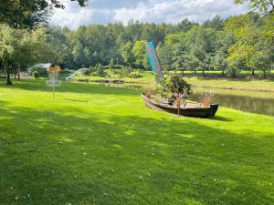a boat sitting in the grass next to a pond at Ramybės parkas 