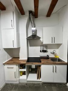 uma cozinha com armários brancos e um lavatório em Beautiful apartment in the center em Barcelona