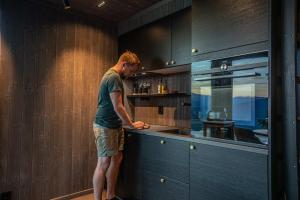 a man standing at a counter in a kitchen at Sørheim FjordPanorama in Skjolden