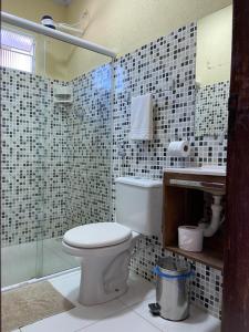 a bathroom with a toilet and a glass shower at Pousada Sitio Araça in São Miguel dos Milagres